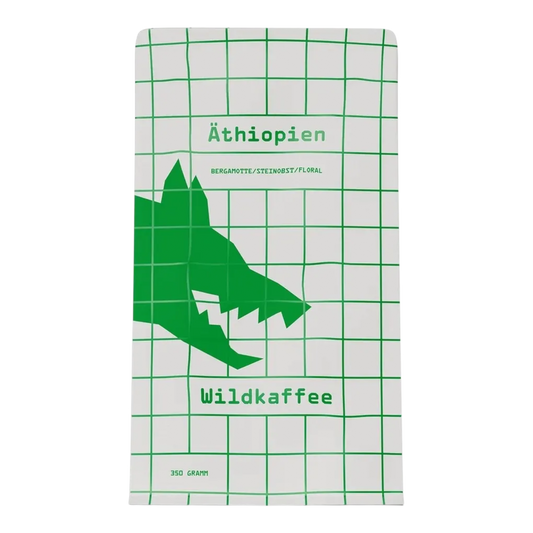 Kaffeekontor Bayern Äthiopien West Arsi Kaffeeverpackung mit grünem Wolf-Logo auf weißem Gittermuster