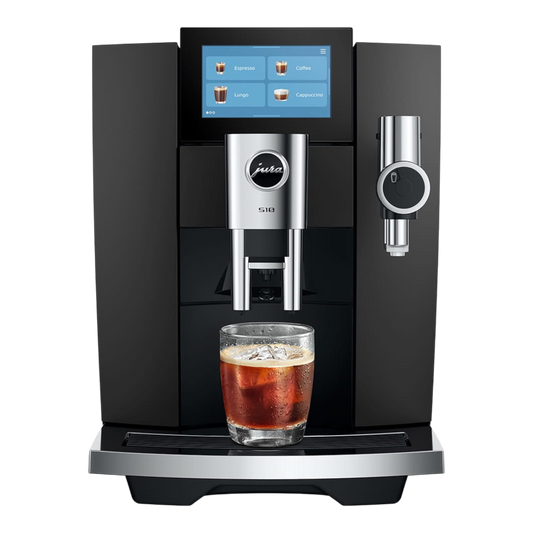 Kaffeekontor Bayern S10 automatic coffee machine in black with a touchscreen display and a glass of cold brew coffee.
